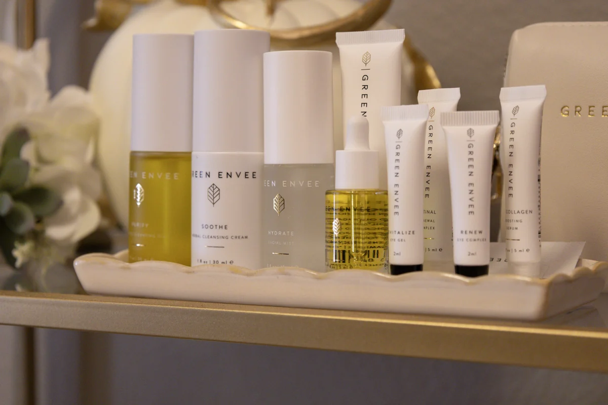 The Green Envee skincare range on a tray in the treatment room — serums, cleansers and oils in white and amber bottles